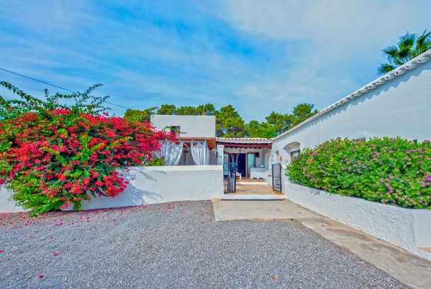 Ibizan style hotel with lush plants at the entrance